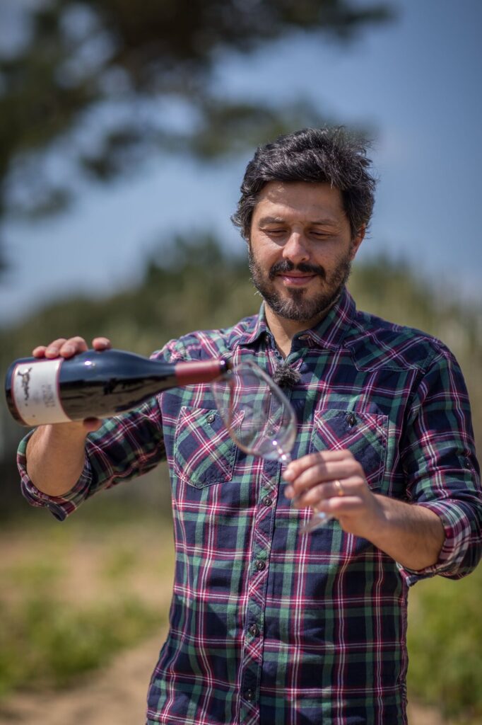 Hélder Cunha serving wine in the century-old vineyard of Colares